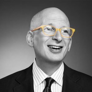 Black and white picture of Seth Godin with suit and yellow glasses